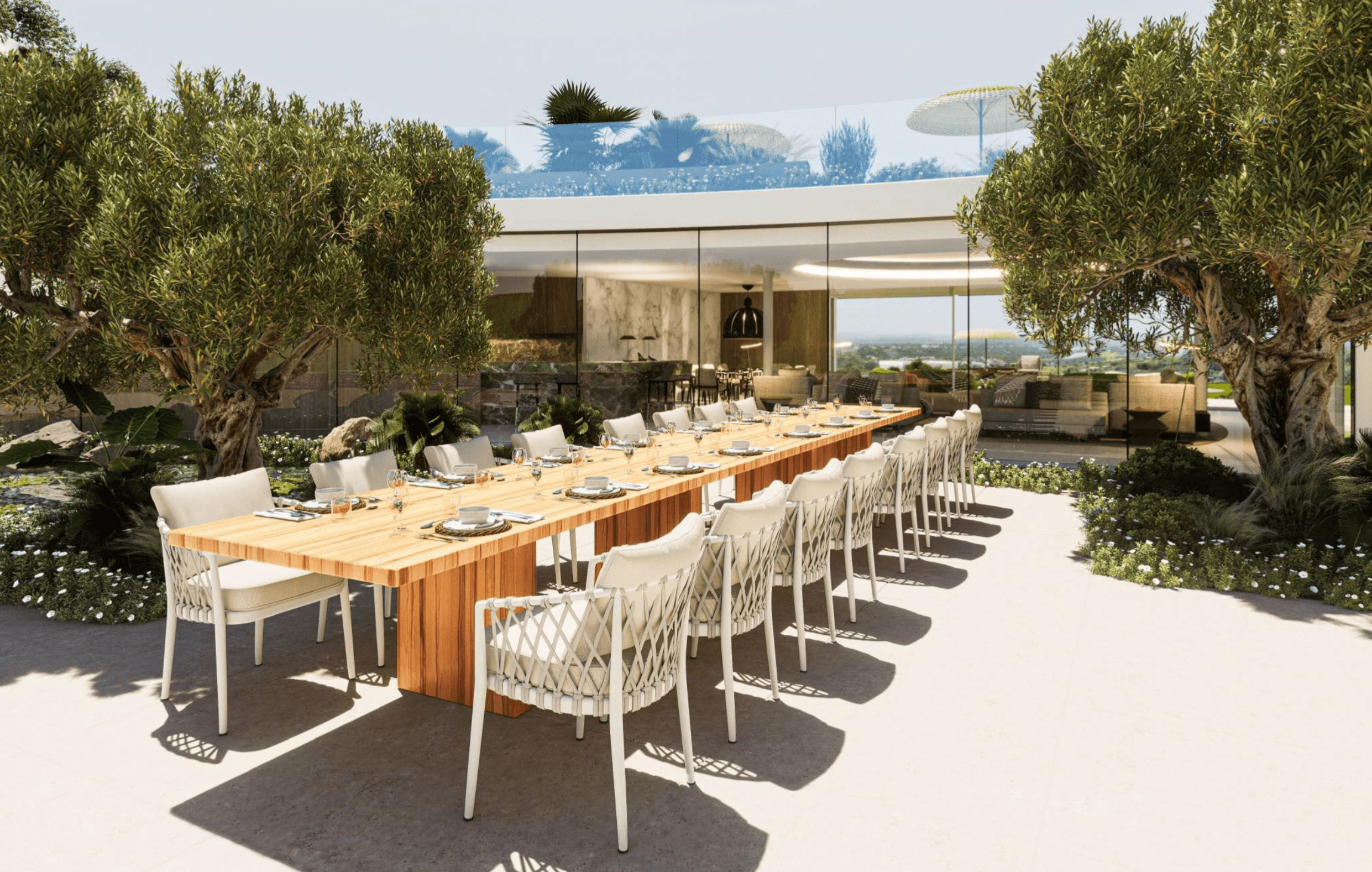 Elegant outdoor dining area with long wooden table and lush greenery in Sotogrande villa