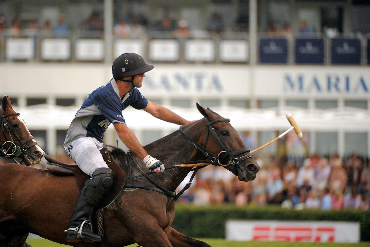 Close-up of a polo player in action during a match at a Sotogrande property, with a focused crowd in the background.