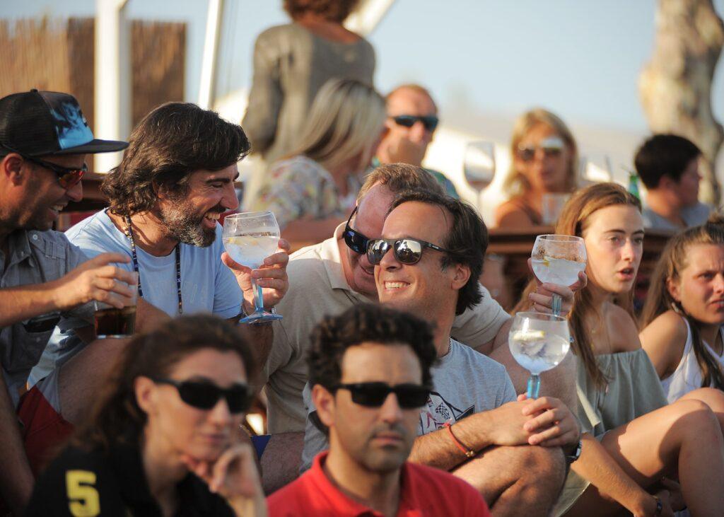 A group of people smiling and enjoying drinks together during a family vacation in Sotogrande, Spain.