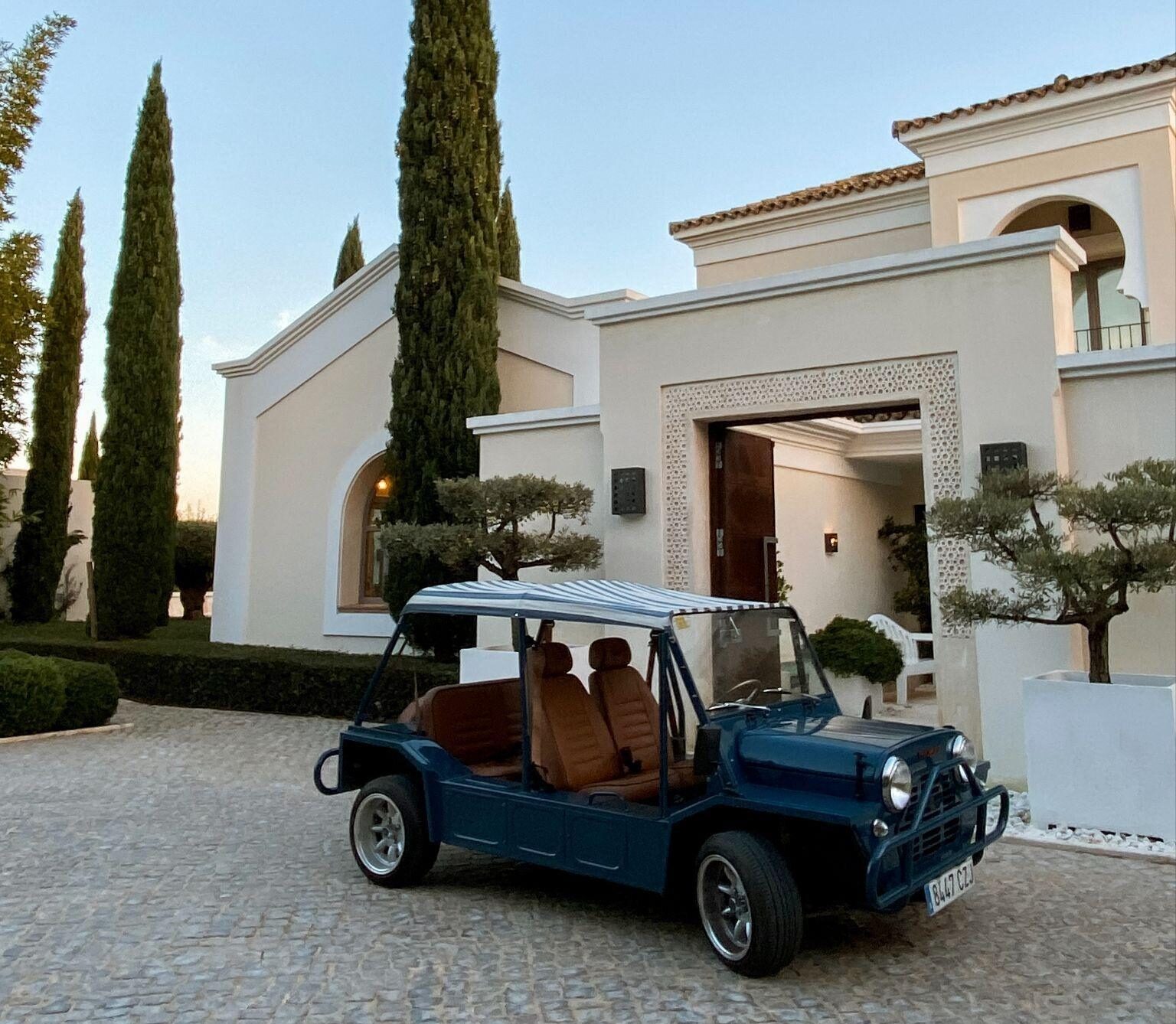 Classic electric Moke parked outside a luxury villa during a Moke experience in Sotogrande